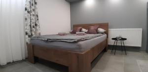 ein Schlafzimmer mit einem Bett mit einem hölzernen Kopfteil in der Unterkunft Apartments Jack in Bihać