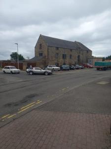 a parking lot with cars parked in front of a building at Full Pint in Tain
