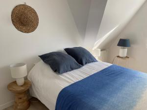 um quarto com uma cama azul e branca com almofadas azuis em Escapade marine à 'l'Abri Côtier' em Deauville