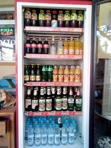 a refrigerator filled with lots of bottles of soda at Семеен хотел Бостън in Ravda