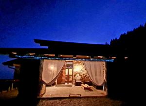 een nachtzicht op een huis met verlichting bij Chalet Chapeau b&b in Castel Condino