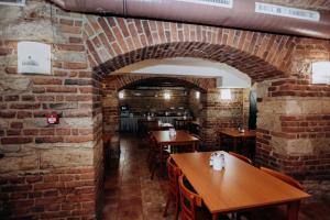 um restaurante com paredes de tijolos e mesas e cadeiras de madeira em Alton em Praga