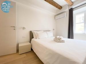 ein Schlafzimmer mit einem großen weißen Bett und einem Fenster in der Unterkunft Cavana 10 Tirabora Short Rent in Triest