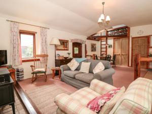 a living room with a couch and a tv at Cuttrye Old Dairy in Totnes