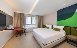 Un dormitorio con una cama, un escritorio y un televisor. en Campanile El Mechtel Tunis, en Túnez