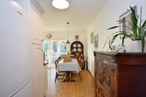 a kitchen with a table and a dining room at Little Crossways , Goodwood in Chichester