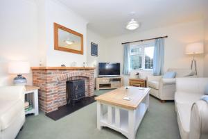ein Wohnzimmer mit einem Sofa und einem Kamin in der Unterkunft Little Crossways , Goodwood in Chichester