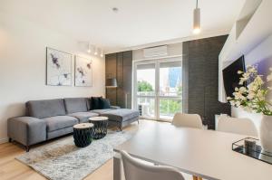 un soggiorno con divano e tavolo di SKY Home- Ilumino Apartment -Centrum, Parking, Klimatyzacja, Dostęp na Kod a Łódź