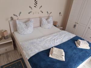 een slaapkamer met een bed met blauwe lakens en kussens bij MINGERS Huus in Neuharlingersiel
