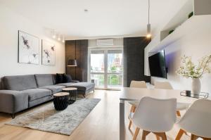 a living room with a couch and a table at SKY Home- Ilumino Apartment -Centrum, Parking, Klimatyzacja, Dostęp na Kod in Łódź