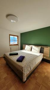 a bedroom with a large bed with a green wall at Apartment Stella in San Lorenzo di Sebato
