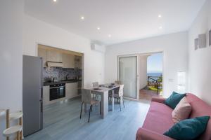 un salon avec un canapé et une cuisine avec une table dans l'établissement Villa Euriclea, à Praiano