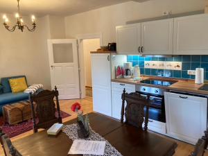 a kitchen with white cabinets and a table in a room at Schatztruhe - Ferienwohnung in Maring-Noviand