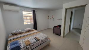 a bedroom with a bed with pillows and a window at Relax Appart Hôtel in Kourou +20 photos