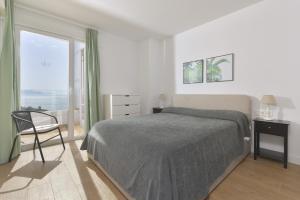 a bedroom with a bed and a chair and a window at Apartamento de lujo vista mar en Torrox Costa in Torrox Costa