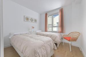 a bedroom with two beds and a chair and a window at Apartamento de lujo vista mar en Torrox Costa in Torrox Costa