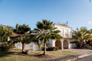 a white house with palm trees in front of it at Sweet Home Grenada Caribbean in Lance aux Épines