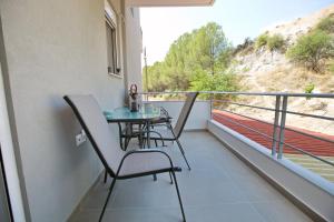 a balcony with a table and chairs on it at Matoulas Luxury Apartment in Nafplio
