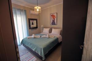 1 dormitorio con 1 cama con 2 toallas en Matoulas Luxury Apartment, en Nauplia