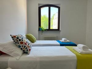 2 camas en una habitación con ventana en Bnbook Olona-Fiera Milano, en Pero
