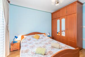 um quarto com uma cama e um armário de madeira em APARTMAN KNEŽEVIĆ em Opric