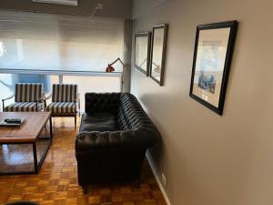 a living room with a leather couch and a table at Castex Palermo Chico in Buenos Aires