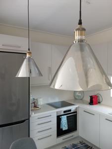 a kitchen with two large pendant lights in a kitchen at Andi's Studio Porto Rafti in Porto Rafti