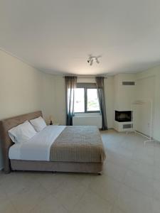 a bedroom with a large bed and a fireplace at Andi's Studio Porto Rafti in Porto Rafti
