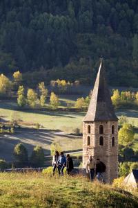 a group of people standing on a hill with a tower at Hotel Deth Pais in Salardú