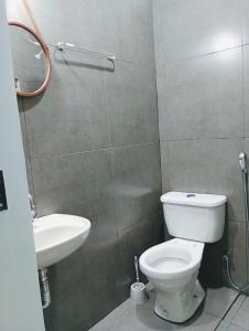 a bathroom with a white toilet and a sink at Rio Quente Pousada do Charme in Rio Quente