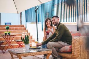 a man and a woman sitting on a couch at Hotel Don Ignacio in San José
