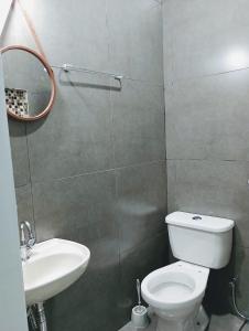a bathroom with a toilet and a sink and a mirror at Rio Quente Pousada do Charme in Rio Quente