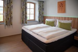 a large bed in a room with two windows at Gasthof zur Post in Lalling