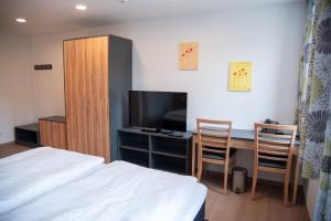 a bedroom with a bed and a desk with a television at Gasthof zur Post in Lalling