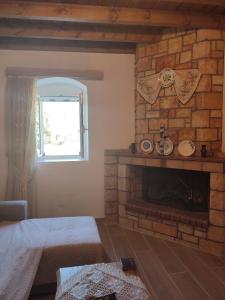 salon z kominkiem z cegły i oknem w obiekcie Villa Jimmy, Pilona Village w mieście vlicha +23 zdjęcia