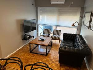 uma sala de estar com um sofá, uma mesa e cadeiras em Castex Palermo Chico em Buenos Aires