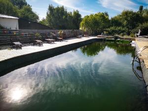 une piscine d'eau entourée de tables et de chaises. dans l'établissement Au Bonheur Nomade, à Livry