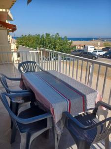 een tafel en stoelen op een balkon met uitzicht op het strand bij Superbe appartement avec vue sur le port et plage in Saint Pierre La Mer