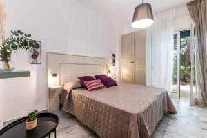 - une chambre avec un lit doté d'oreillers violets dans l'établissement Villa Coralia a 20mt dalle spiagge, à Torre Santa Sabina