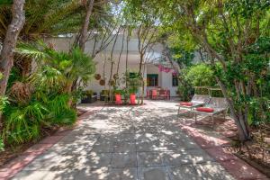 une terrasse avec bancs et arbres devant une maison dans l'établissement Villa Coralia a 20mt dalle spiagge, à Torre Santa Sabina