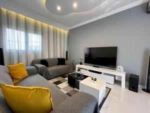 a living room with a couch and a flat screen tv at Luxurious Modern Home in Kalamaria, Thessaloniki in Thessaloniki