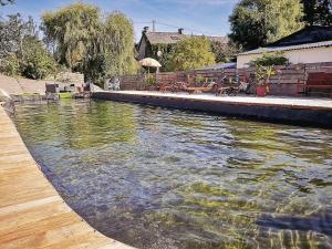 une grande piscine d'eau à côté d'une maison dans l'établissement Au Bonheur Nomade, à Livry