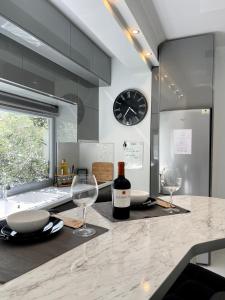 una cucina con bancone, due bicchieri da vino e un orologio di Luxurious Modern Home in Kalamaria, Thessaloniki a Salonicco