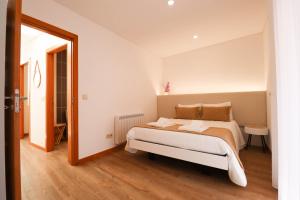 Un dormitorio con una gran cama blanca en una habitación. en Tourinho's House - Apt in the Historic Centre of Viana, en Viana do Castelo