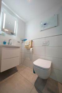 居特斯洛的住宿－貝克旅館，白色的浴室设有卫生间和水槽。