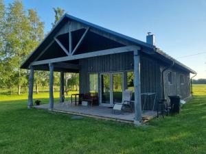 a barn with a deck with a table and chairs at IEVKALNI in Jūrkalne