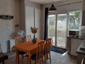 a kitchen and dining room with a wooden table and chairs at Maisonnette proche de la plage in Tarnos