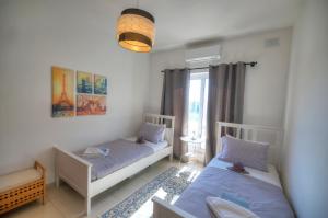 una camera da letto con due letti e una finestra di Charming 2 bedroom apartment close to Junior College ETUS1-1 a Msida