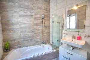 un bagno con vasca, lavandino e doccia di Charming 2 bedroom apartment close to Junior College ETUS1-1 a Msida Altre 17 foto