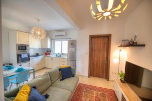 un soggiorno con un divano, un tavolo e una cucina di Charming 2 bedroom apartment close to Junior College ETUS1-1 a Msida